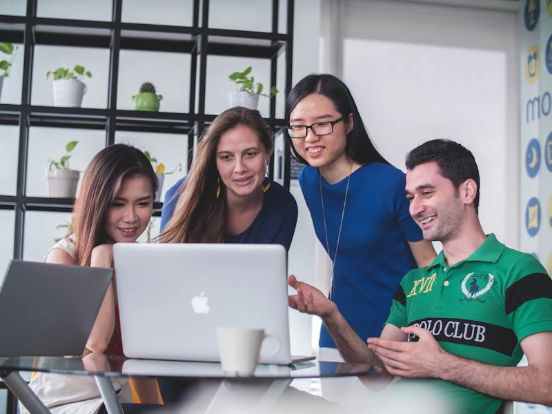 Four colleagues discussing a design on a laptop